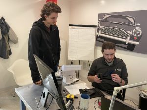Applications engineer and summer intern look at a 3D printed part