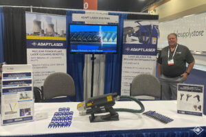 Laser sales man stands behind table at a booth at a tradeshow